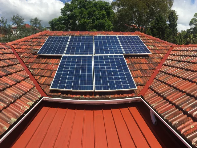 Restored terracotta tile roof with a freshly coated deep red metal skillion.