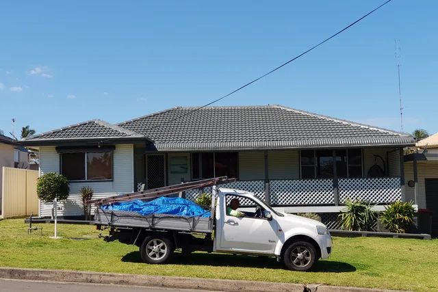 Work ute parked outside a house with a restored charcoal tile roof.