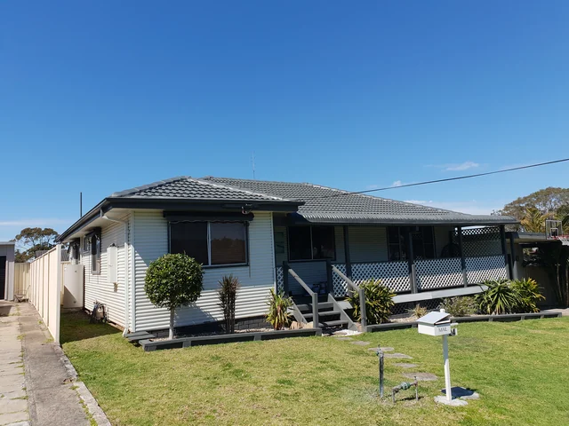 Pale blue clad house with a restored charcoal tile hip roof.