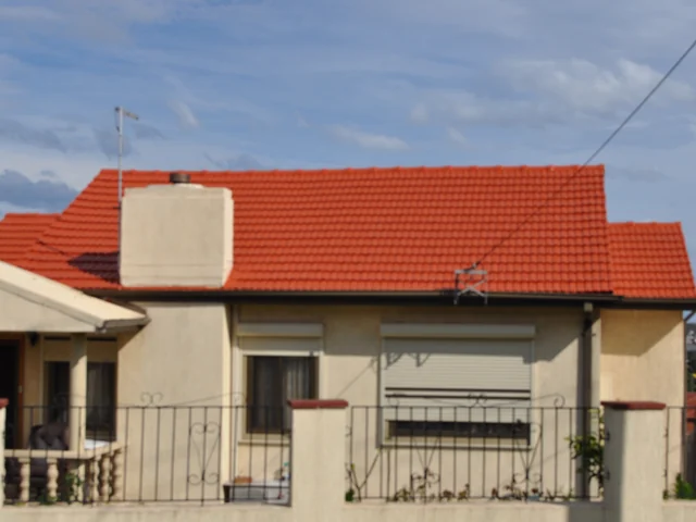 Rendered house with a restored terracotta tile roof and a rendered chimney.